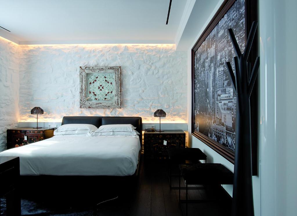 sypialnia z białym łóżkiem i obrazem na ścianie w obiekcie Areadocks Boutique Hotel w mieście Brescia
