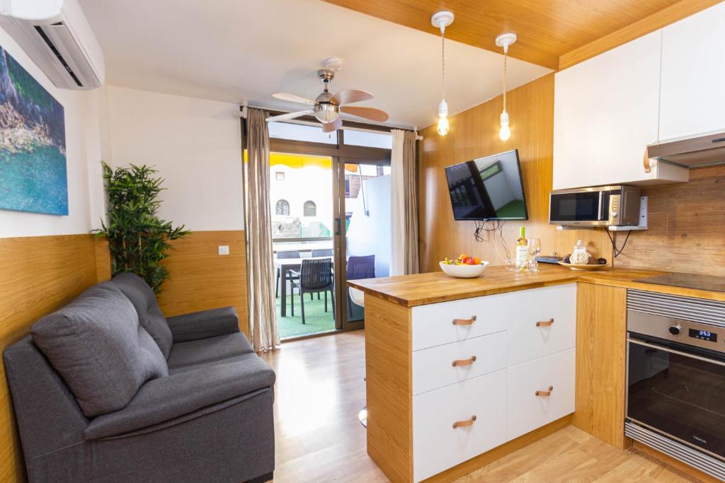 Una cocina con un sofá y una silla en una habitación. en Sand Friendly Holiday Home, en Playa del Inglés