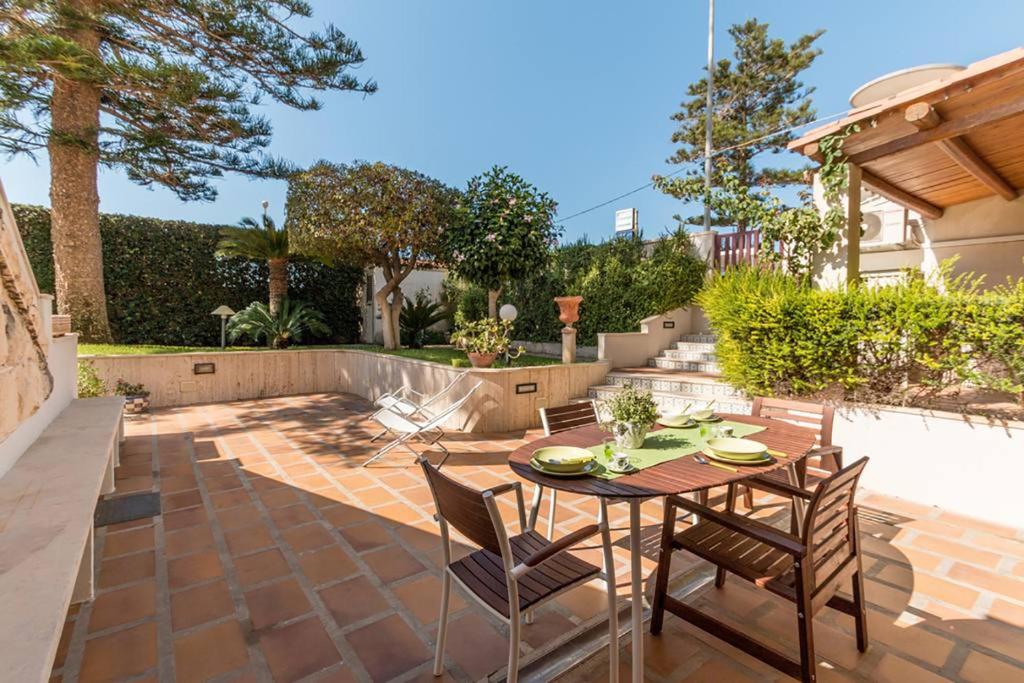 a patio with a table and chairs in a backyard at Case Madira in Marina di Ragusa