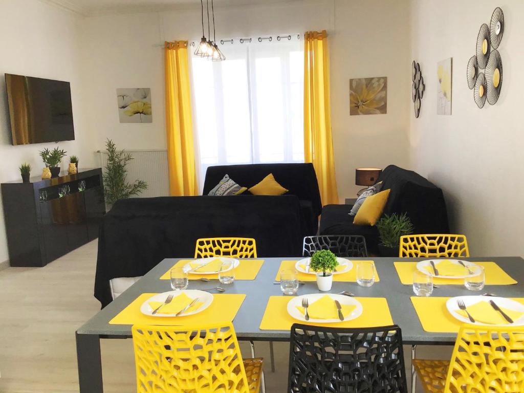 a living room with a table and yellow chairs at Appartement Le Solea 100m2 climatisé parking proche Sanctuaires in Lourdes