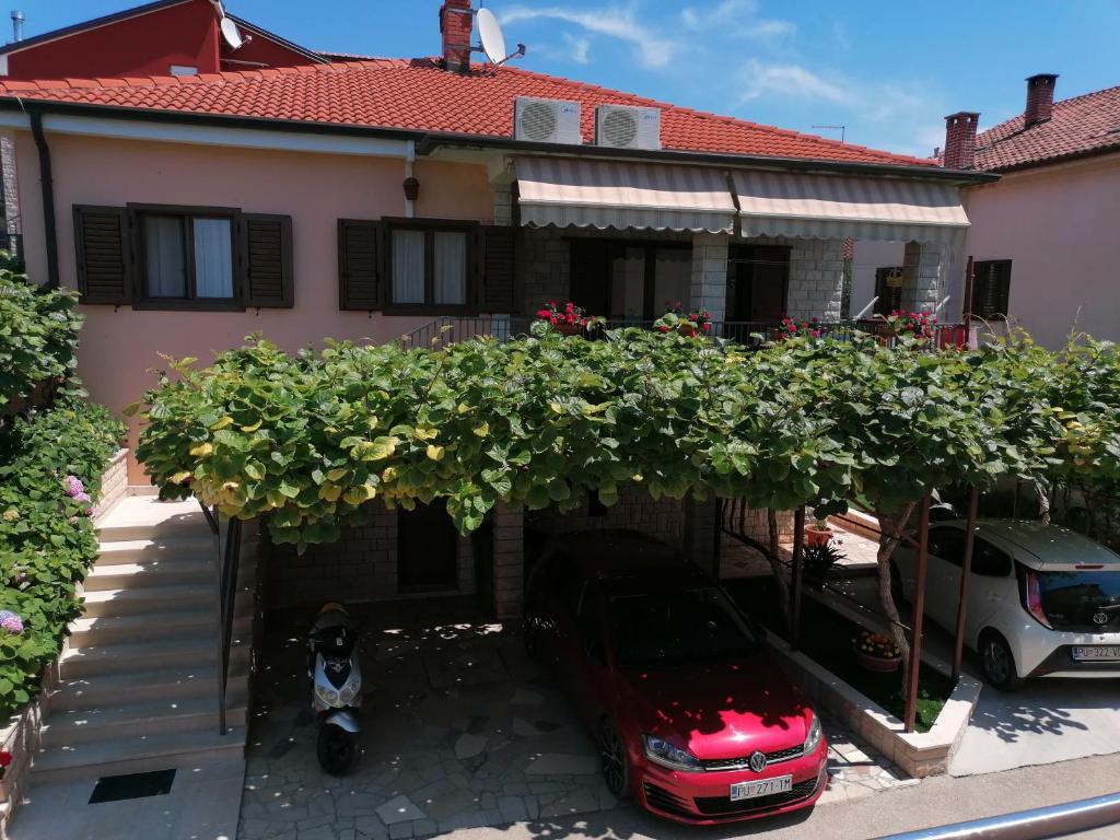 una casa con un coche aparcado delante de ella en Apartman Bruna, en Novigrad Istria