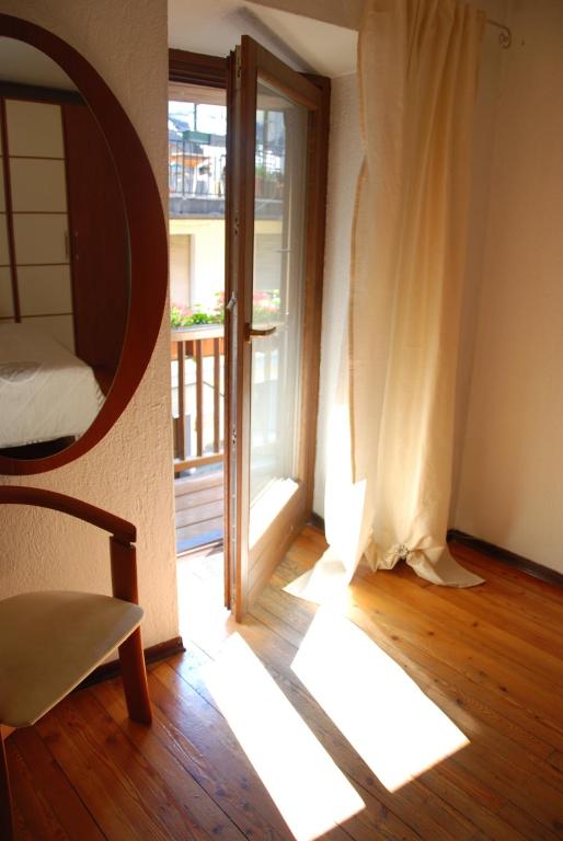 Habitación con ventana, silla y espejo. en Cà Mia en Nus