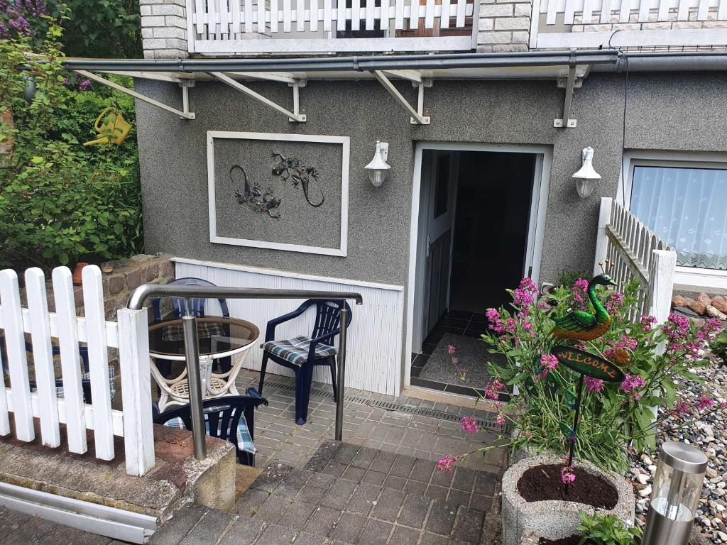 a house with a table and chairs and a fence at Ferienwohnung Sonnenschein in Sagard