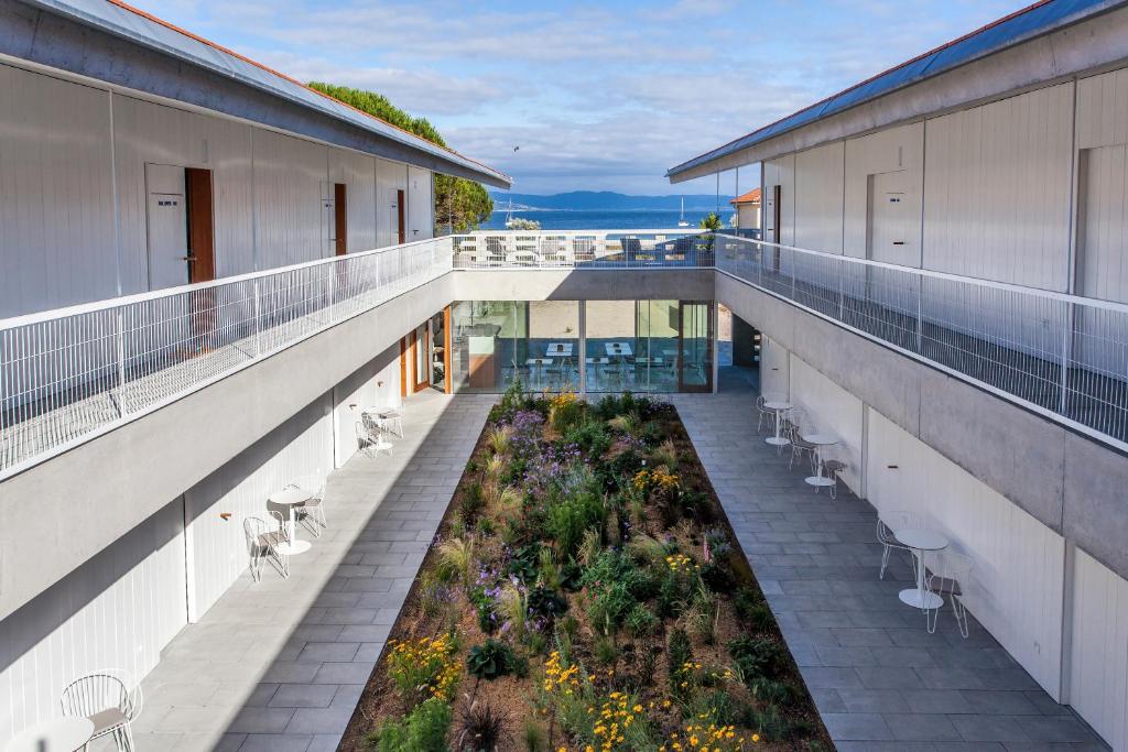 uma varanda vazia com um jardim num edifício em Hotel Bela Fisterra em Finisterre