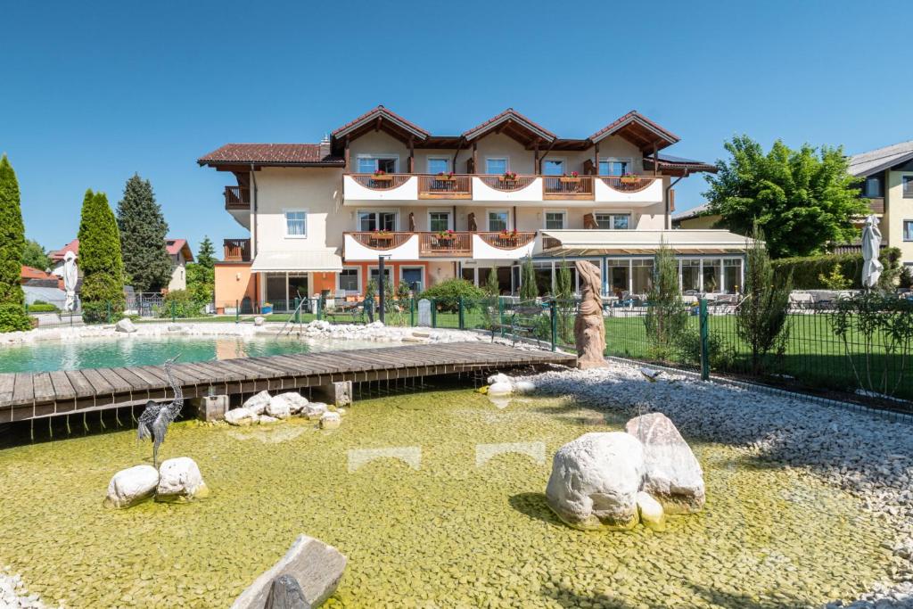 a large building with rocks in front of a yard at Hotel Himmelreich in Wals