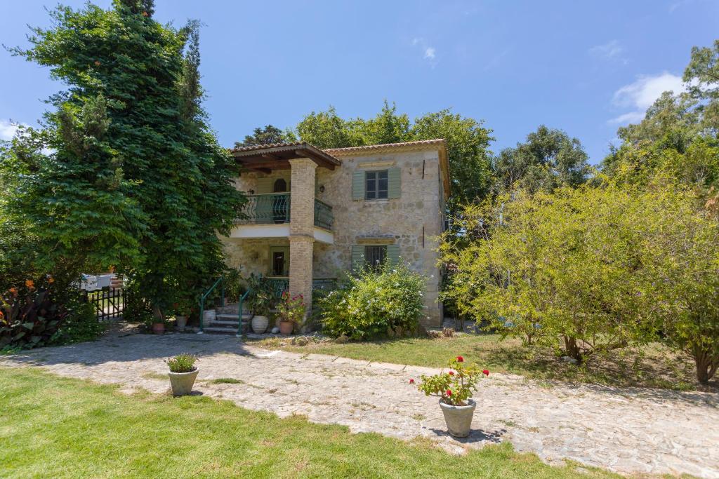 a large stone house with trees in the yard at Jianni's Villa - Stone Villa in the Greenery!! in Vasilikos
