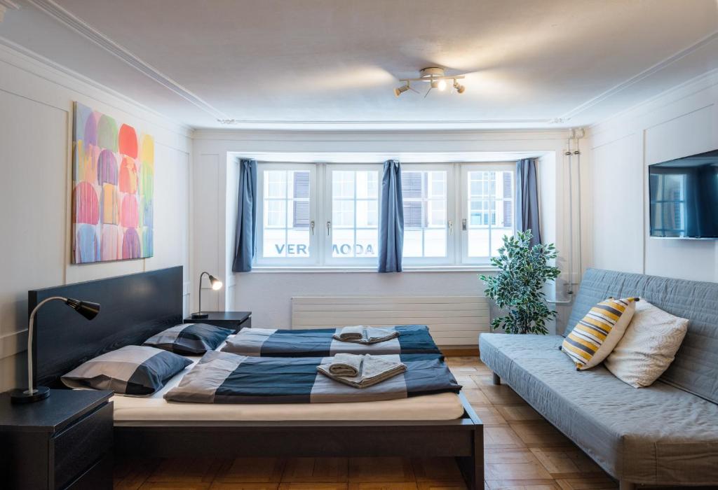 1 dormitorio con 1 cama y 1 sofá en HITrental Niederdorf - Apartments, en Zúrich