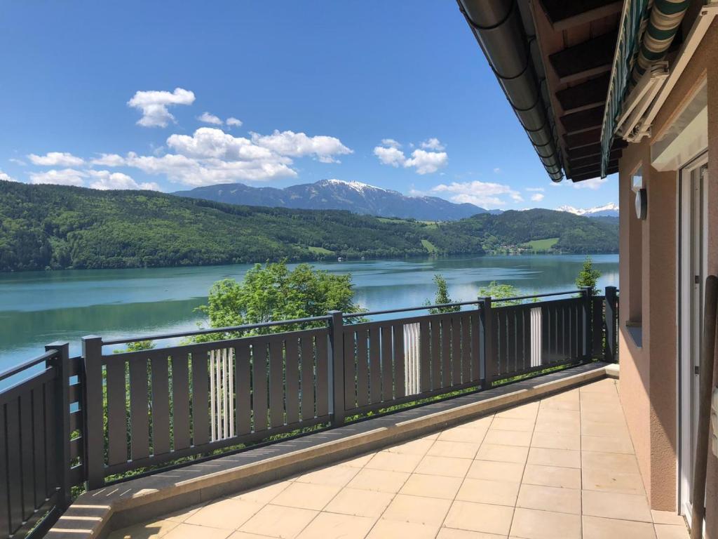 a balcony with a view of a river and mountains at Seeblick in Döbriach