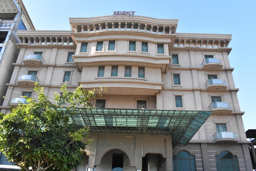 een gebouw met een glazen loopbrug ervoor bij Grand Regency Hotel in Pothi