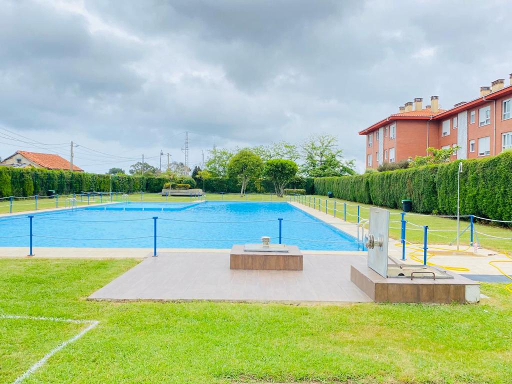 a large swimming pool with a bench in the grass at NEXT STOP PLAYA SALINAS in Salinas
