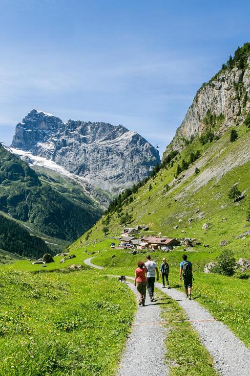 a group of people walking down a path on a mountain at Hotel Central in Engelberg