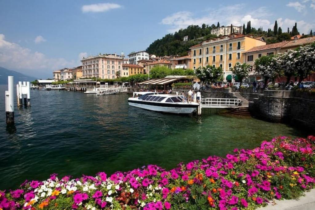 una barca è ormeggiata su un fiume con fiori di Captivating 4 -Bed Apartment in Bellagio Historic a Bellagio