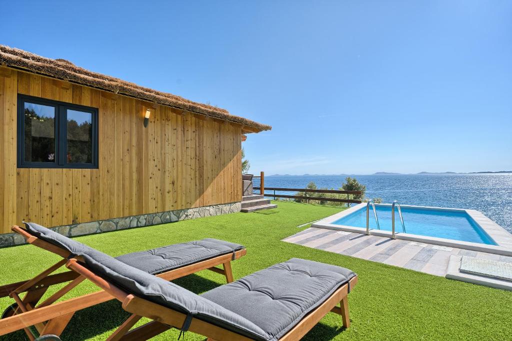 een achtertuin met een huis en een zwembad bij Kamp Lunga + in Jezera