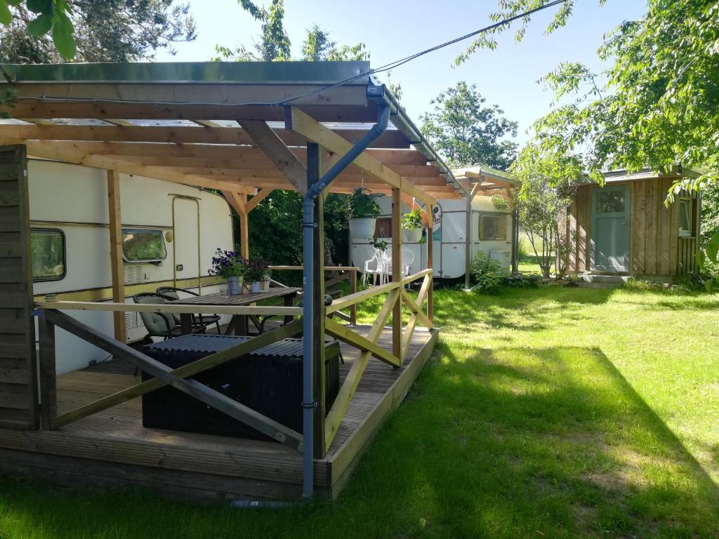 a pergola on a deck in a yard at Caravan in Samtens