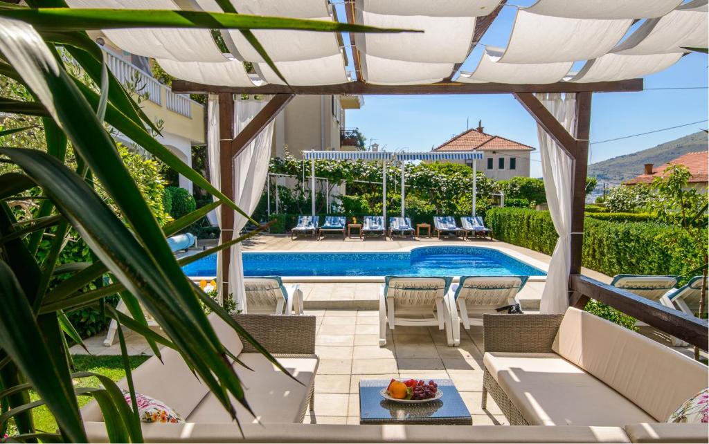 un patio con tavolo, sedie e piscina. di Apartments Kasalo a Trogir