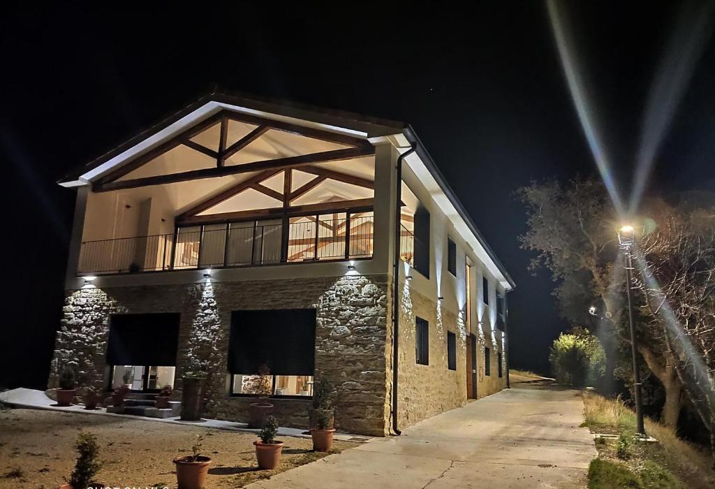 un gran edificio de piedra con balcón por la noche en CASA SARTZALETA-Navarra-España en Aramendía