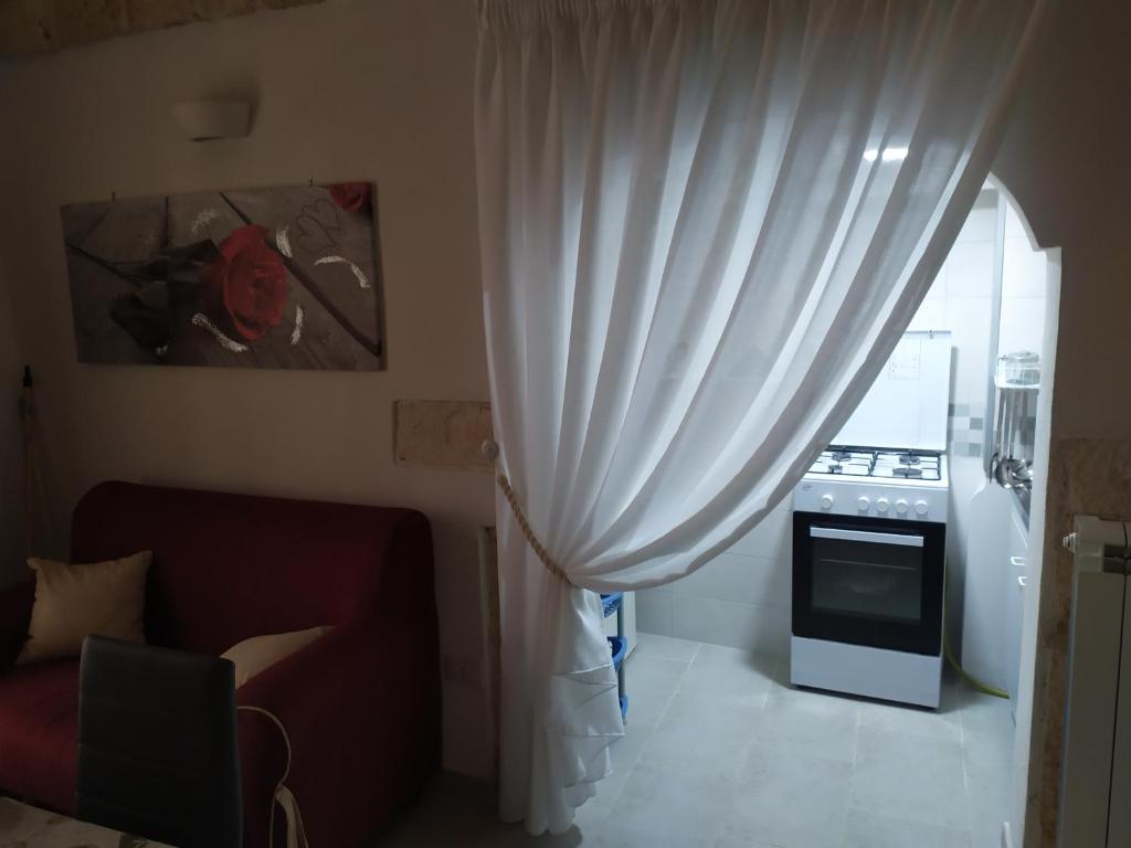 a living room with a white curtain and a stove at Soggiorno Galasso in Ostuni
