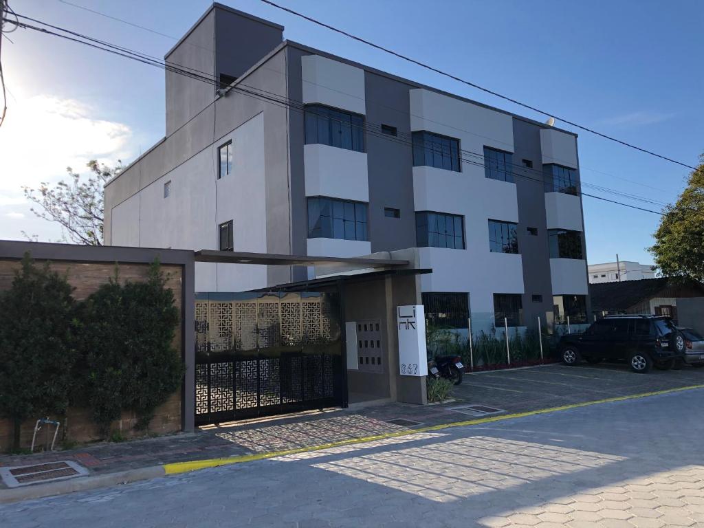 a white building with a gate in front of it at Link Araranguá in Araranguá