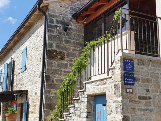 a brick building with a balcony and a blue door at Casa dei Boscarini in Buje