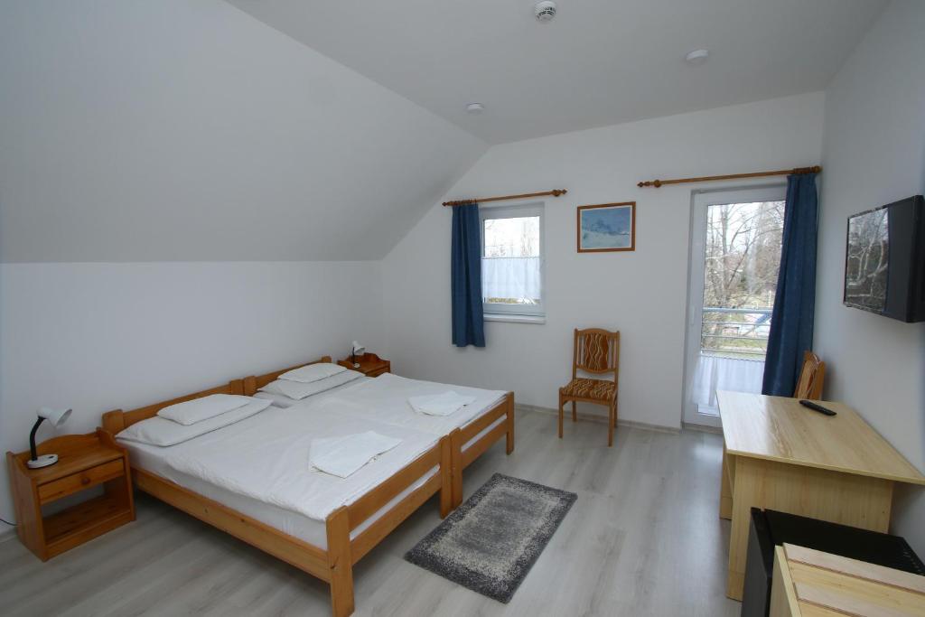 - une chambre avec un lit, un bureau et une fenêtre dans l'établissement Hotel Aqua, à Komárom