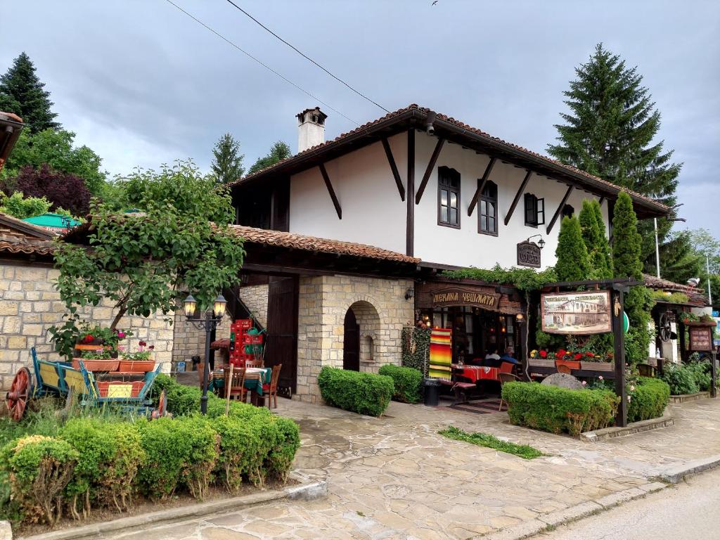 un edificio con mesas y sillas en un patio en Guest Rooms Cheshmata en Arbanasi