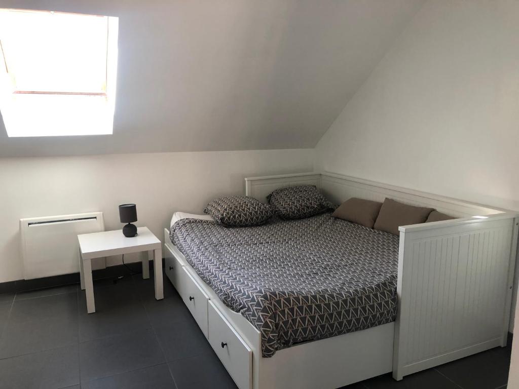 ein weißes Schlafzimmer mit einem Bett und einem Fenster in der Unterkunft Grand studio centre historique Sancerre in Sancerre