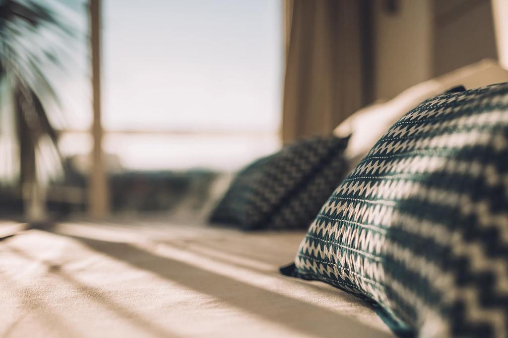 a couch with pillows on top of it at Las Gaviotas Suites Hotel & Spa in Playa de Muro