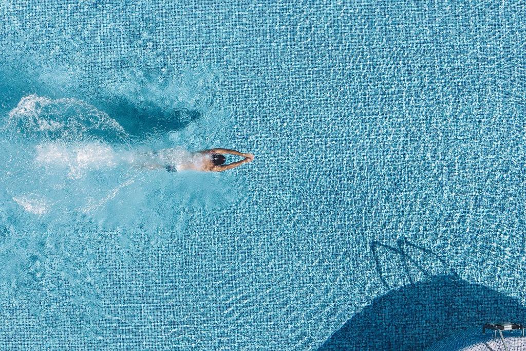 a person swimming in the water in a pool at Las Gaviotas Suites Hotel & Spa in Playa de Muro