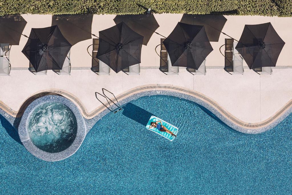 an overhead view of a swimming pool with umbrellas at Las Gaviotas Suites Hotel & Spa in Playa de Muro