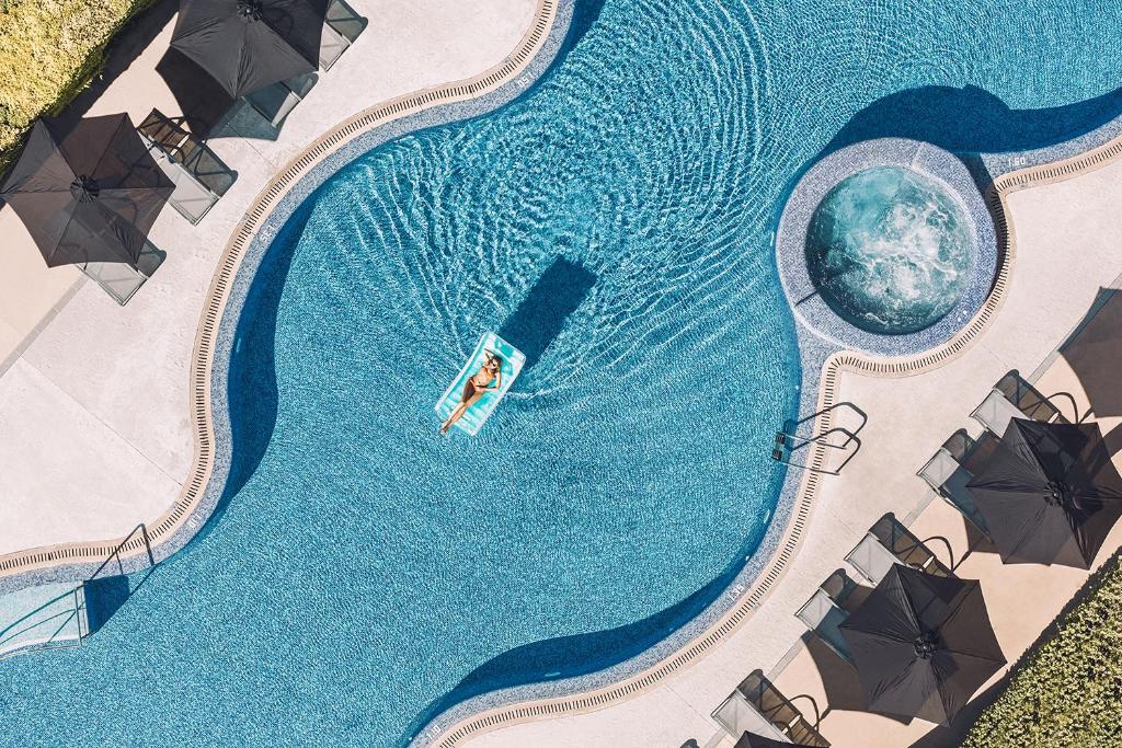 an overhead view of a swimming pool with umbrellas at Las Gaviotas Suites Hotel & Spa in Playa de Muro