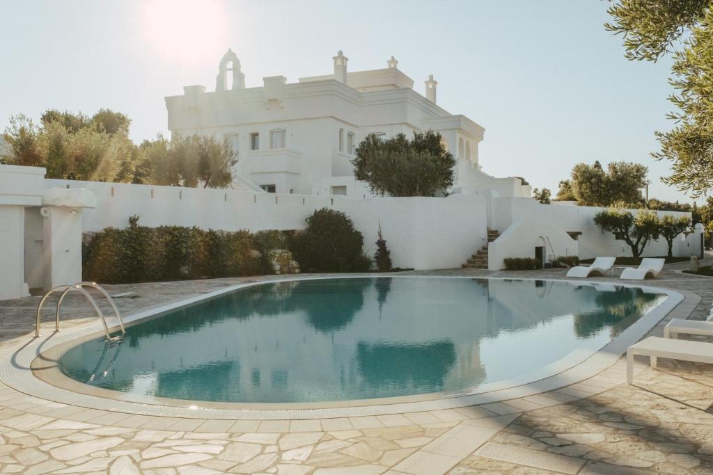 una piscina di fronte a una casa bianca di Masseria Borgo Ritella a Fasano