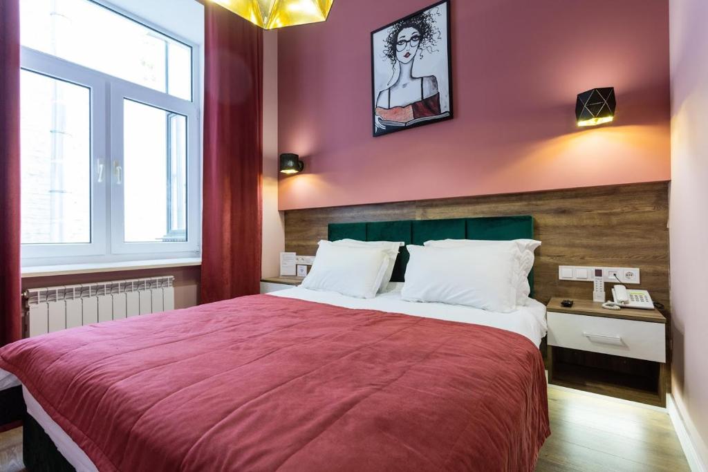 - une chambre avec un grand lit et une couverture rouge dans l'établissement Partner Guest House Velyka Vasylkivska, à Kiev