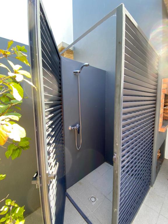 a shower stall in a bathroom with a glass door at Bordal Houses Casa da Areia in Porto Santo