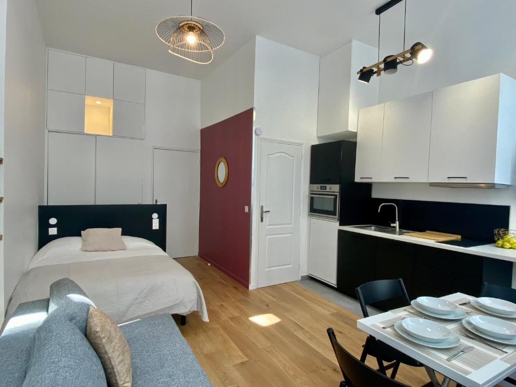 Un dormitorio con una cama y una mesa con platos. en Studio Aboukir 2 en París