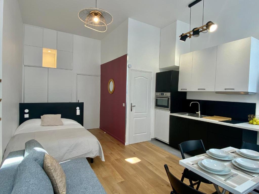 - une chambre avec un lit et une table avec des plaques de cuisson dans l'établissement Studio Aboukir 2, à Paris