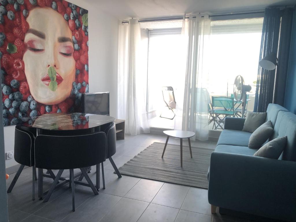 a living room with a large painting of a woman at Appartement naturiste PaulAna Port Ambonne 314 in Cap d'Agde