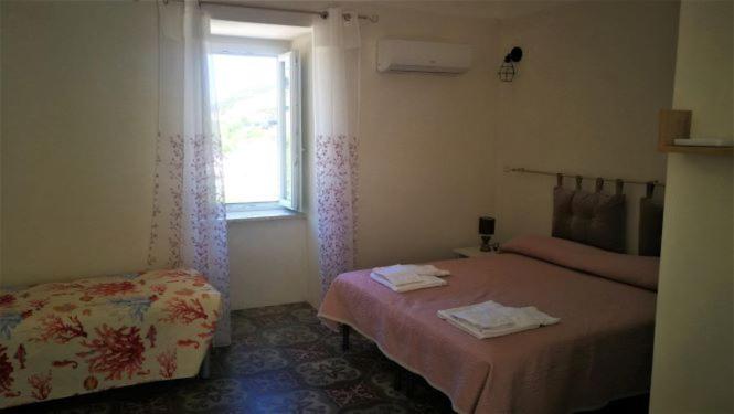 a bedroom with two beds and a window at Visitponza - La casa di Eolo in Ponza