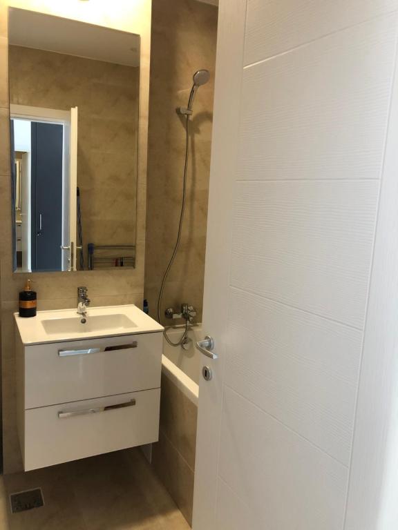 a bathroom with a white sink and a shower at Hils Pallady Bucharest apartments in Bucharest