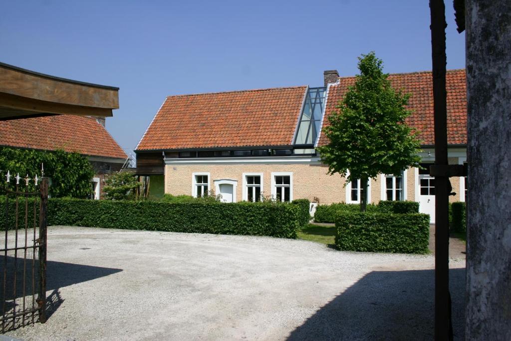 une grande maison blanche avec un toit rouge dans l'établissement Miniloft Abel Abri, à Zingem