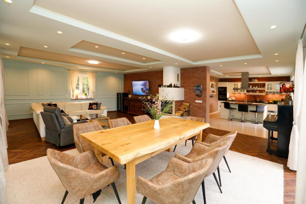 jadalnia z drewnianym stołem i krzesłami w obiekcie Iseroase House Deluxe w mieście Pobiedna