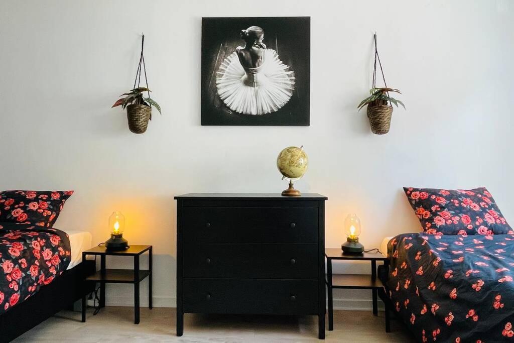 a bedroom with a bed and a dresser with two candles at Au coeur de la ville in Spa