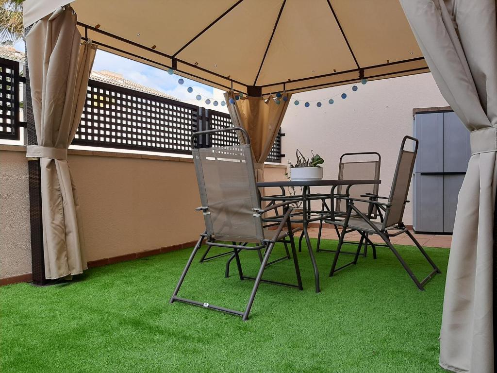 un patio con mesa y sillas bajo una sombrilla en Gran terraza con piscina, en Sant Jaume d'Enveja