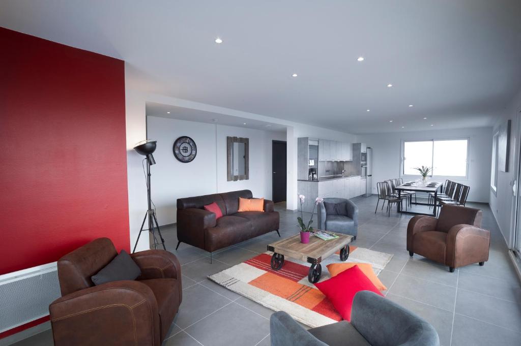 una sala de estar con muebles marrones y una pared roja. en Appartement Tournette - Vue Lac, en Sévrier