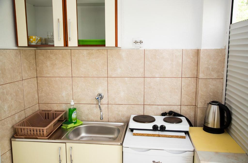 a small kitchen with a sink and a stove at 4 Studios Becic in Budva