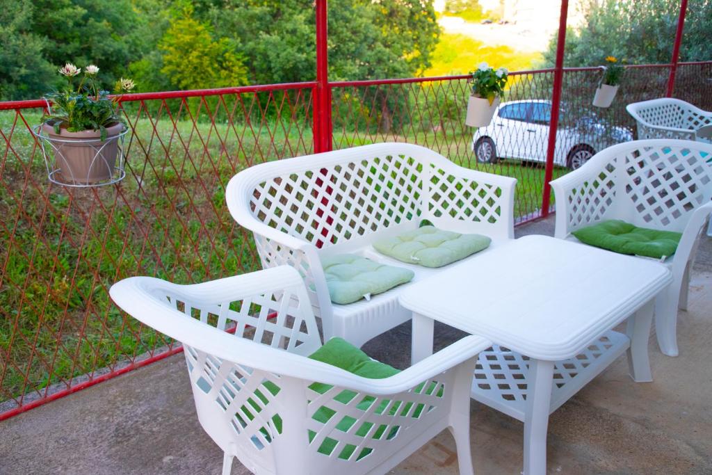 two white chairs and a table on a patio at 4 Studios Becic in Budva