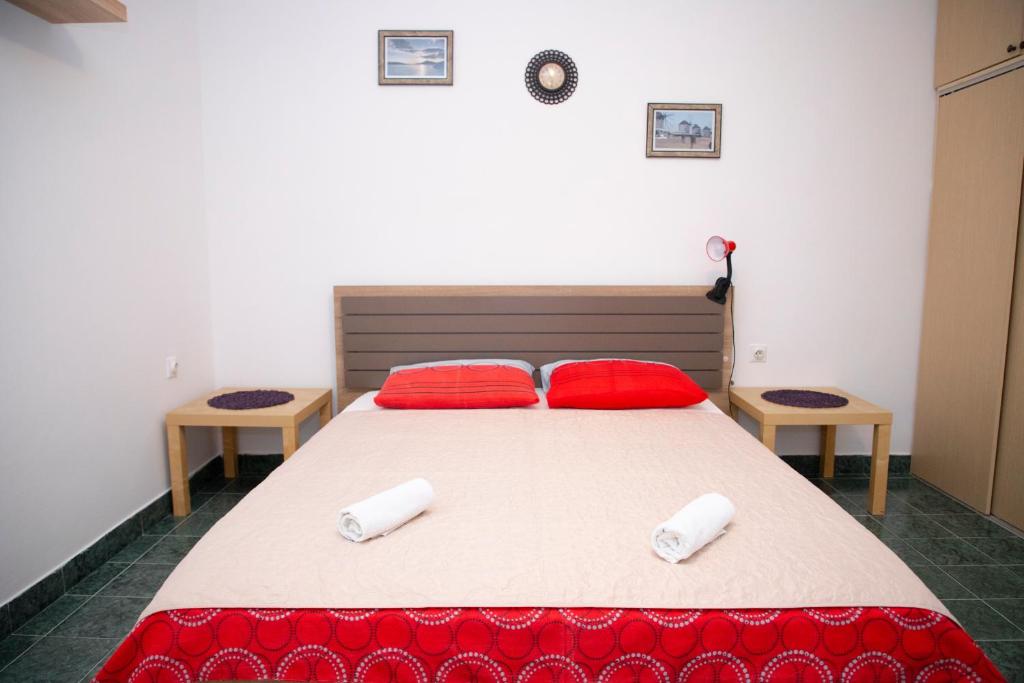 a bedroom with a large bed with red pillows at 4 Studios Becic in Budva