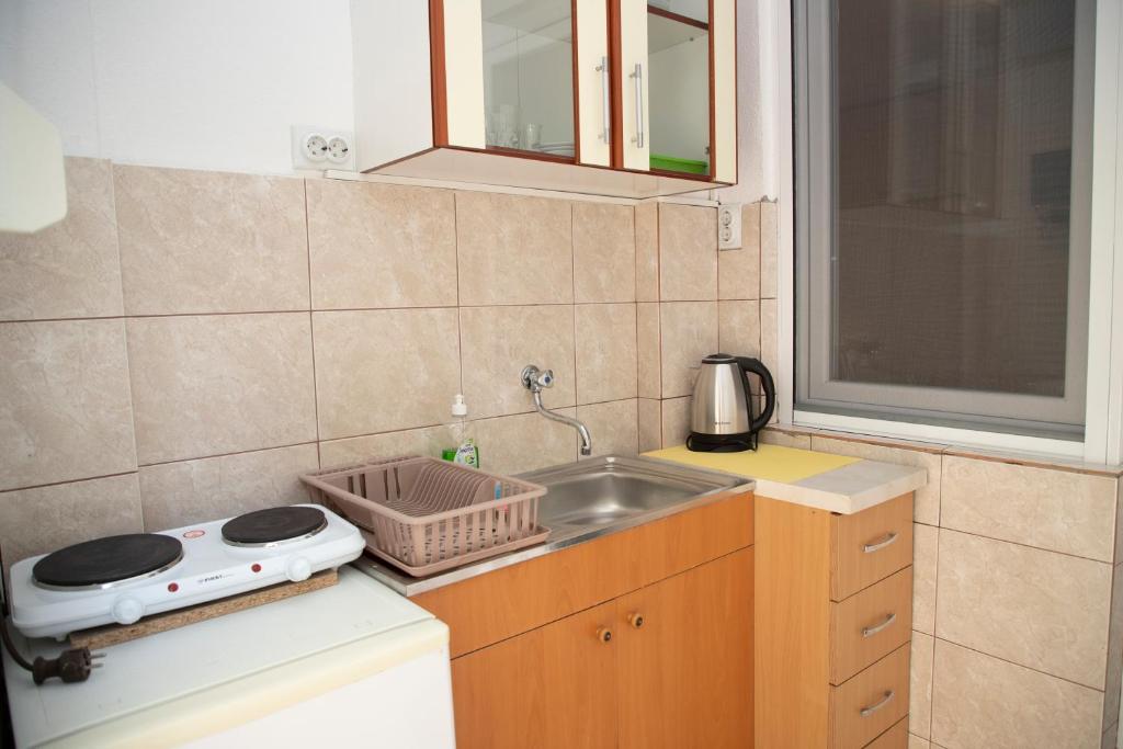 a small kitchen with a sink and a stove at 4 Studios Becic in Budva