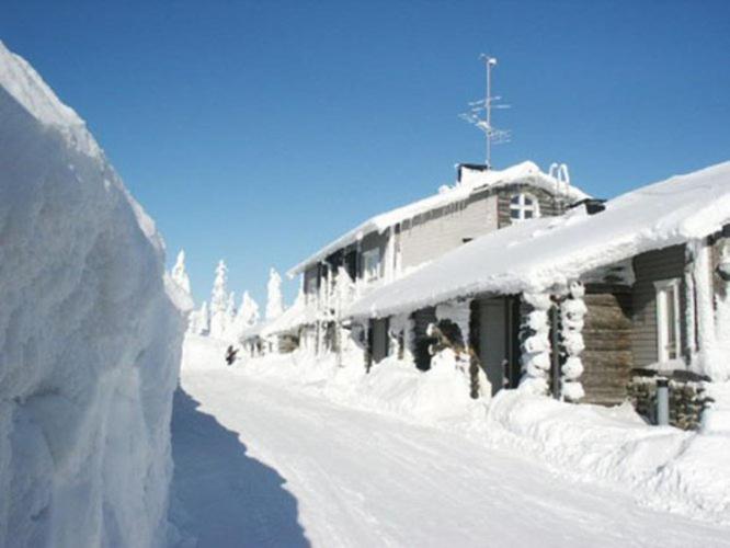un edificio cubierto de nieve con un montón de nieve en Näköalahuoneisto 413, en Syöte