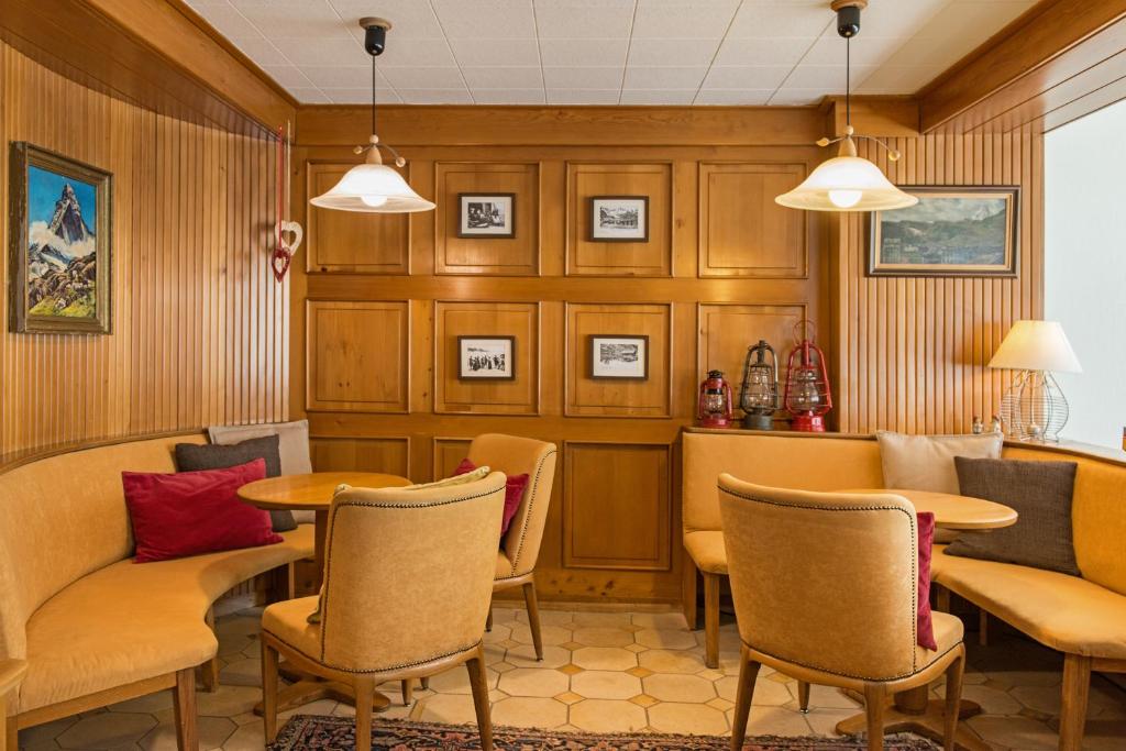 ein Restaurant mit Stühlen und Tischen in einem Zimmer in der Unterkunft Hotel Alpina in Zermatt