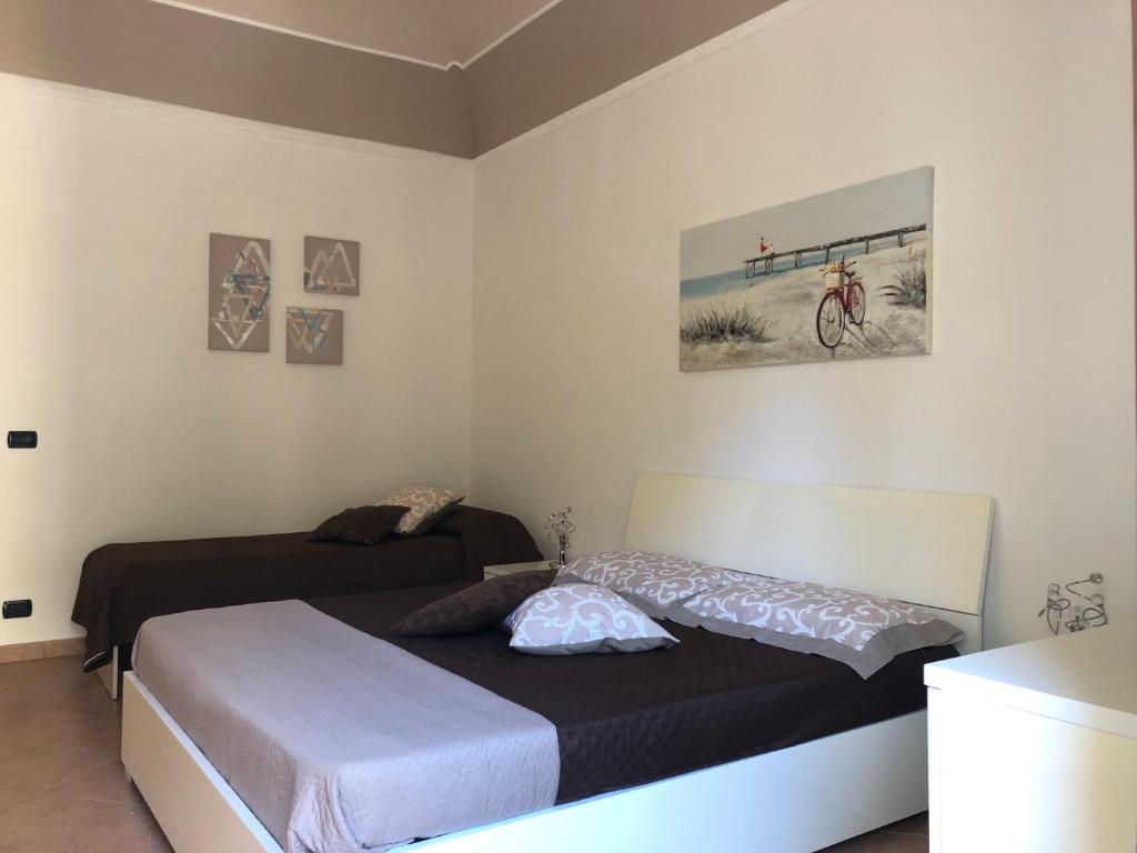 a bedroom with two beds and a bike on the wall at La Casa Sulla Scogliera in Cefalù